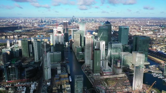 Aerial bird's eye panoramic video taken by drone of iconic Canary Wharf skyscraper complex and business district with beautiful clouds, Isle of Dogs, London, United Kingdom