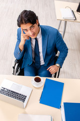 Male employee in wheelchair working at the office