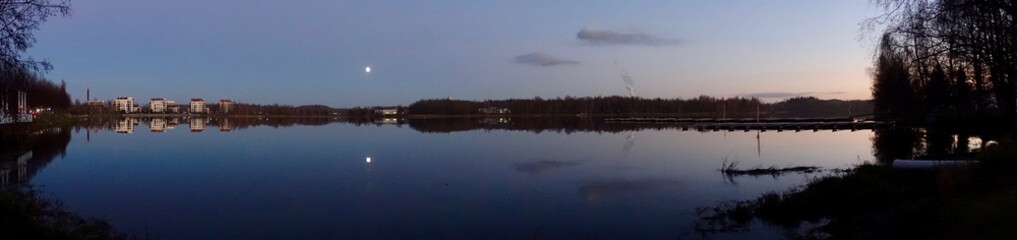 Obraz premium Beautiful lake scene panorama at night. Calm water and the moon on the clear sky.