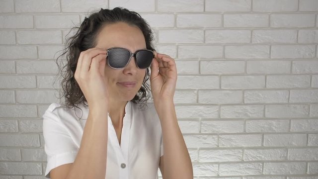 Woman wearing training glasses. The female puts on the obscura glasses.