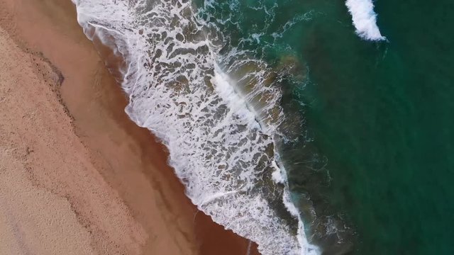 4k backward aerial view of waves motion over gradient blue sea water