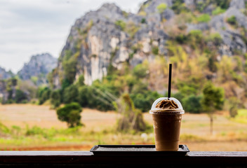 Fototapeta premium Cold coffee amid nature and mountains