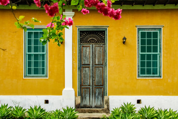 Fototapeta na wymiar Casa de fazendo porta e janelas parece amarela, janelas verdes e porta natural