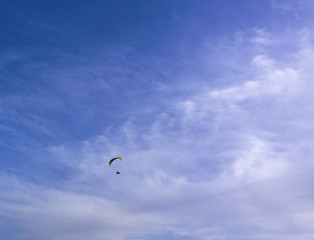 Paraglider flying, deep blue sky with some clouds. Clean Monday holiday. Athens, Greece 2019.