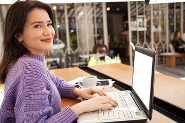 Young woman is working with computer in cafe