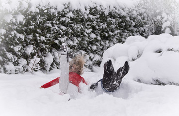 Mother and son jumping in deep snow, having fun