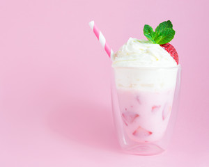 Strawberry smoothie or milkshake with whipped cream on pink background. Healthy food for breakfast and snack.
