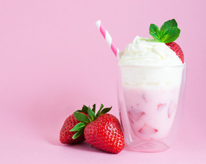 Strawberry smoothie or milkshake with whipped cream and strawberry fruit on pink background. Healthy food for breakfast and snack.