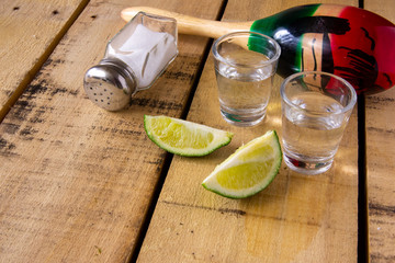 Tequila shots with lime slices on table with decorations.