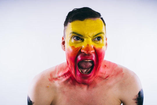 Crazy Guy Posing With A Painted Face. A Bizarre Portrait Of A Man With A Painted Body. Concept: Sports Fan