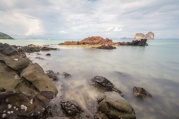 Fototapeta premium Long exposure shot. Sea scape with stone beach at sunset, Motion blur, slow shutter speed
