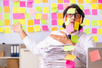 Young employee in conflicting priorities concept
