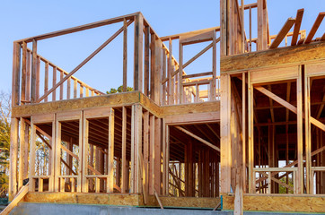 Obraz premium New house under construction framing against a blue sky