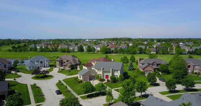 AERIAL: lifting past a mini tree line to reveal the suburbs of Chicago.