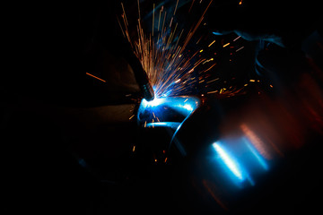 Arc welding. Welding of two metal plates in inert gases. MIG / MAG. A bright flash of light and a...