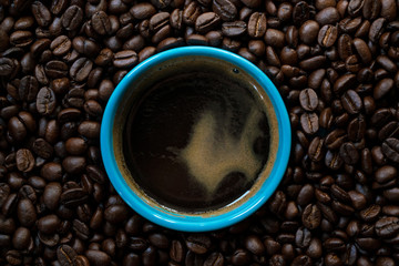 Coffee background, top view. Blue cup of coffee, ground coffee, coffee beans on table background