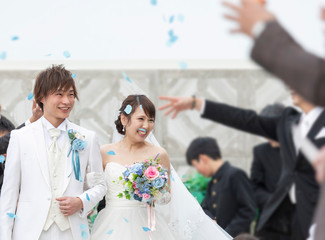結婚式　フラワーシャワーで祝福される笑顔の新郎と新婦