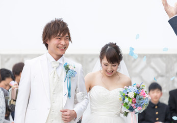 結婚式　フラワーシャワーで祝福される笑顔の新郎と新婦