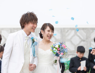 結婚式　フラワーシャワーで祝福される笑顔の新郎と新婦