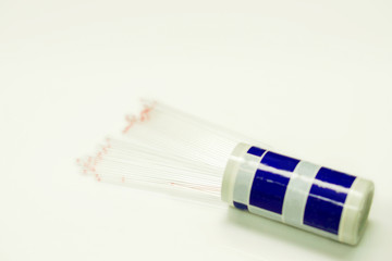 Top view of medical capillary glass tube spread and container on light gray background., Designed for both safe blood collection as well as accurate micro-hematocrit determinations Precision.