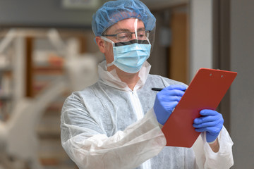 Doctor with clipboard in protective clothing and gear