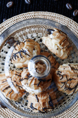 Cake profiteroles with butter cream and chocolate against a dark background. Soft focus.