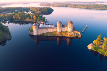 The medieval fortress of Olavinlinna in the morning landscape (aerial photography). Savonlinna,...