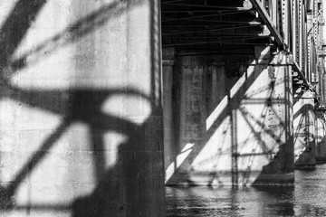 Shadows from a bridge support are cast against a pillar
