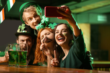 Company of good friends in st.patricks day costumes making photos