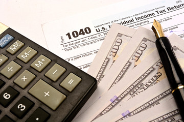 Calculating US tax with 1040 tax form on white background