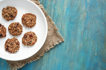 Obraz na płótnie Canvas home made oat cookies with raisin on white plate on blue wooden background top view copy space . healthy food