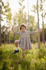 Little girl in nature field wearing beautiful dress