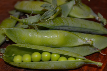 Fresh pea pods close-up on brown background
