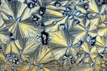 Colorful micro crystals in polarized light. Photo through a microscope.