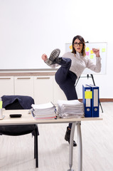 Young female employee doing exercises at workplace