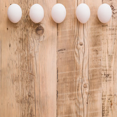 Top view on fresh eggs on natural wooden table. Easter festive background. Celebration concept