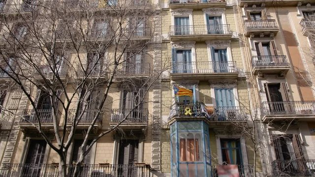 BARCELONA, SPAIN - FEBRUARY 2019. Full shot. Balcony on the house in Barcelona where the flag of Catalonia and the yellow protest tape are placed. The concept of separatism and detachment from Spain