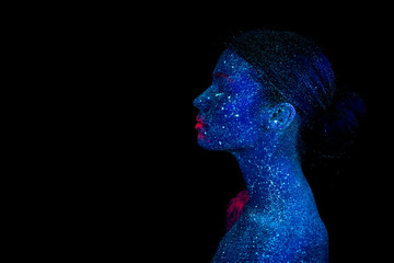 Profile of an alien woman with blue skin and pink lips, ultraviolet makeup on a black background.