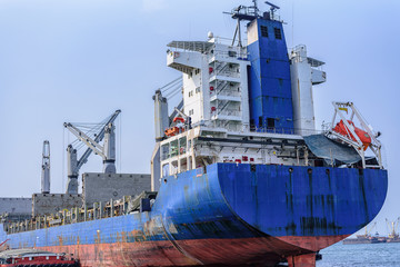 A large cargo ship is moving in the sea and moving goods.