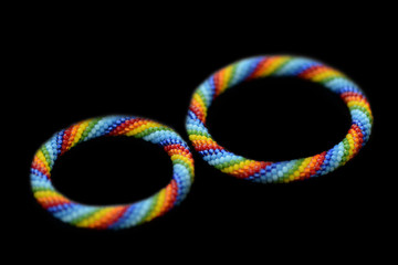 Set of rainbow mother-daughter bracelets isolated on a black background close up