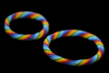 Set of rainbow mother-daughter bracelets isolated on a black background close up