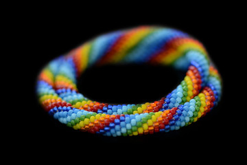Set of rainbow mother-daughter bracelets isolated on a black background close up
