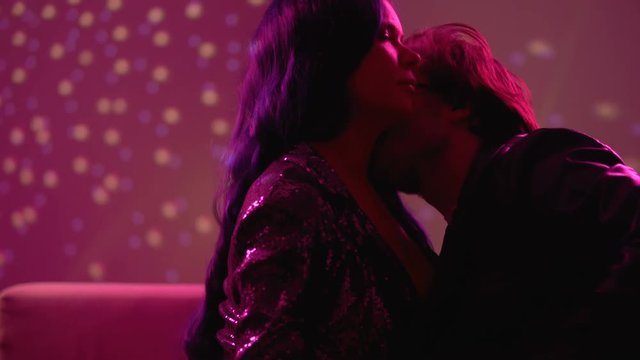 Passionate man kissing girl at party, seducing for one night sex, risk of std