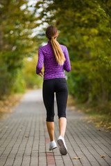 Young woman running in city park