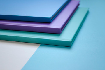 stack of multicolored books on a neutral background