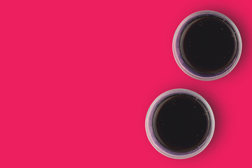 Pair of full glasses of aerated cola with bubbles on red table in cuisine. Copy space for your text. Top view. Rest concept