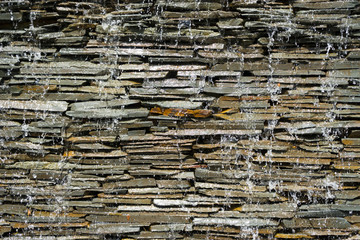 stone wall with a waterfall in garden