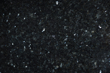 Natural stone of dark color with bright sparkles with bluish tint, called labradorite Emerald Pearl