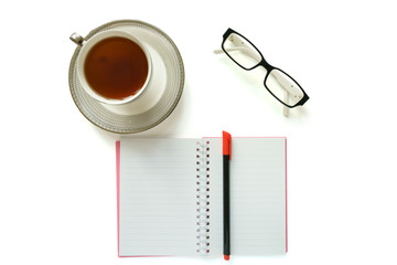 A cup of tea, notebook, pen and eyeglasses