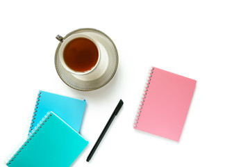 A cup of tea, notebooks and pen